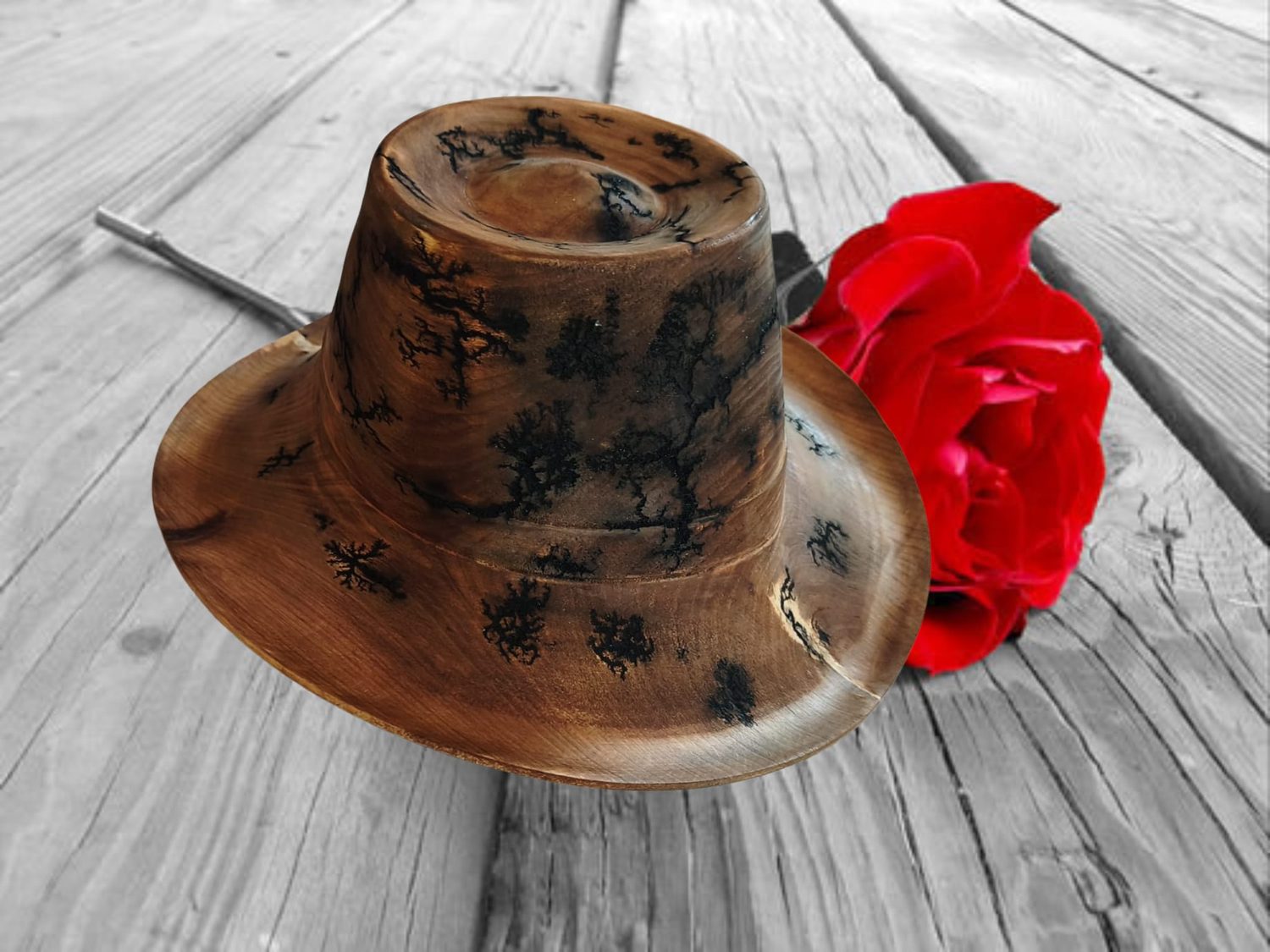 Dunkler Holzhut mit roter Rose